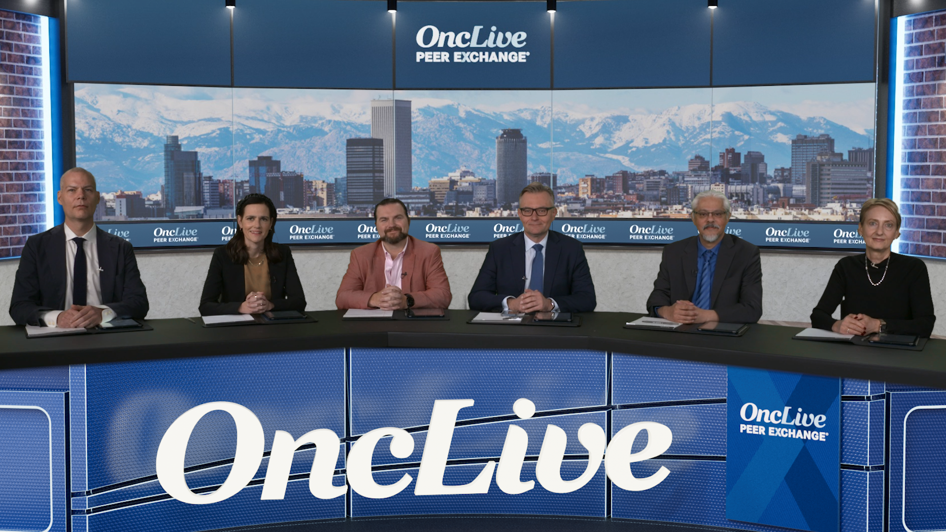 A panel of 6 experts on follicular lymphoma and mantle cell lymphoma seated at a long desk