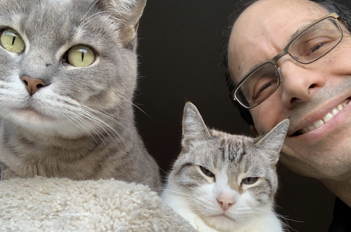 Small with his cats, from left, Emme and Micah, who appear to have mixed feelings about being photographed.